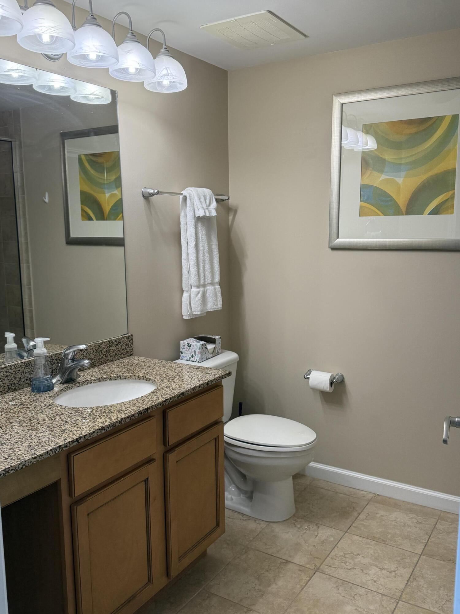 4203 Indian Bayou Trail, Unit 1816 Destin, FL 32541 - Photo 13 of 17 a bathroom with a granite countertop toilet sink and mirror