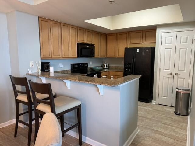 4203 Indian Bayou Trail, Unit 1816 Destin, FL 32541 - Photo 8 of 17 a kitchen with stainless steel appliances granite countertop a refrigerator a stove top oven a sink dishwasher and wooden cabinets