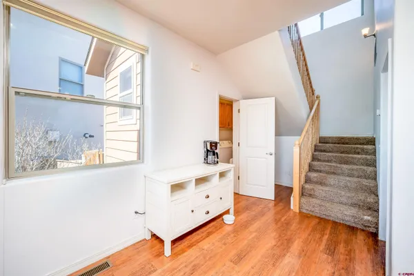 a view of a bedroom with wooden floor and stairs