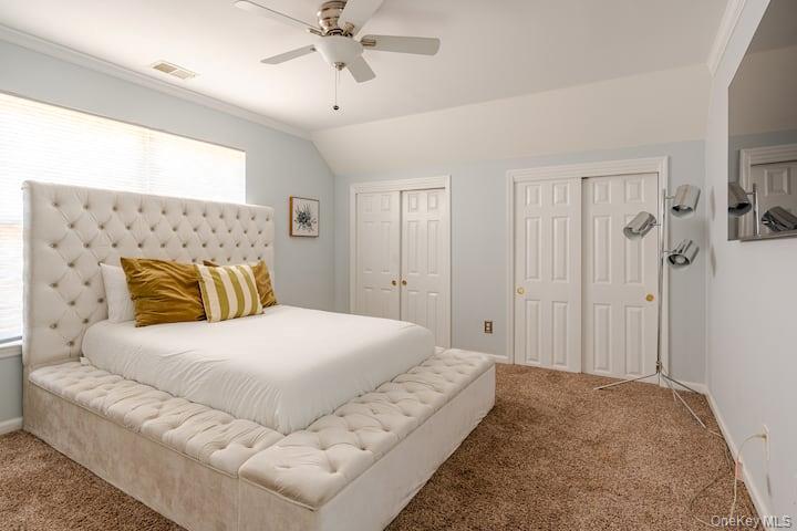 1 Brittany Court Ridge, NY 11961 - Photo 20 of 40 a bedroom with a large bed and a chandelier
