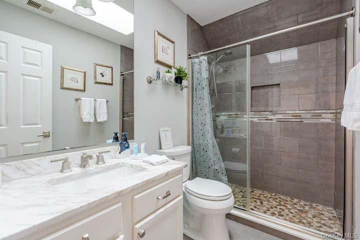 1 Brittany Court Ridge, NY 11961 - Photo 24 of 40 a bathroom with a granite countertop sink toilet and shower