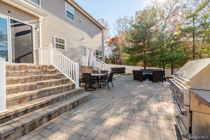 1 Brittany Court Ridge, NY 11961 - Photo 26 of 40 a view of a patio with table and chairs with wooden floor and fence