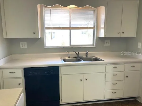 a kitchen with cabinets appliances a sink and a window