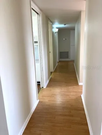 a view of a hallway with wooden floor