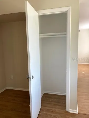 a view of an empty room with wooden floor