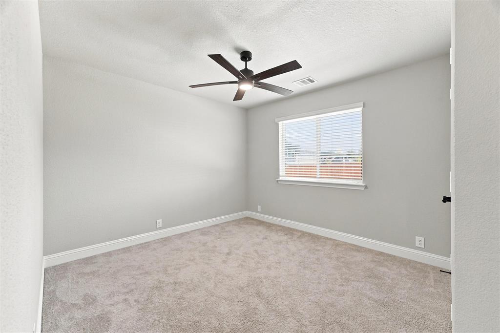 5225 Rowlan Row Midlothian, TX 76065 - Photo 20 of 33 Spacious bedroom with neutral wall finishes, plush carpeting, and abundant natural light from a large window with plantation shutters