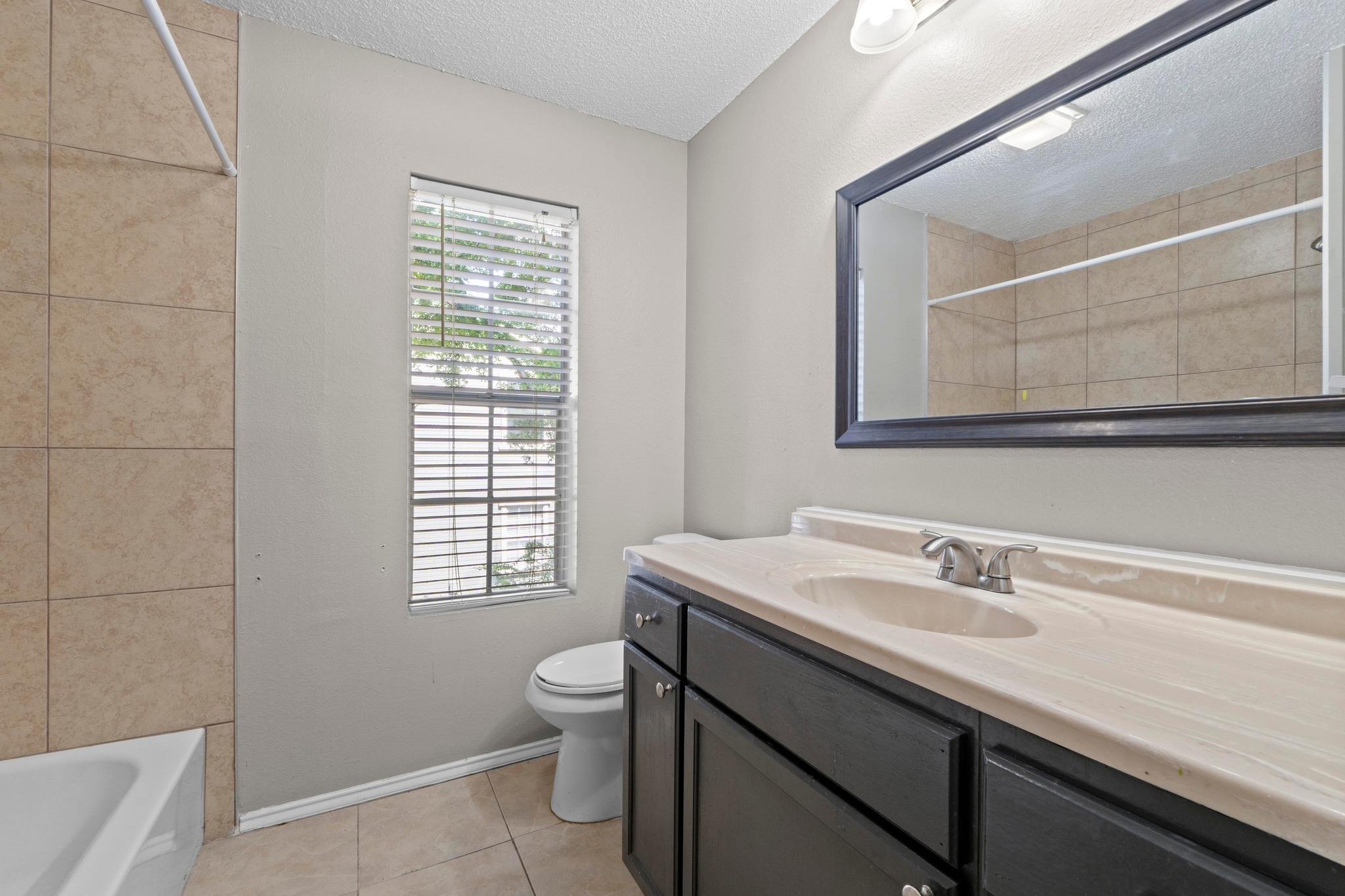 4208 Duval Road, Unit C Austin, TX 78759 - Photo 20 of 28 Bathroom featuring vanity, a textured ceiling, tile patterned flooring, and shower / tub combination