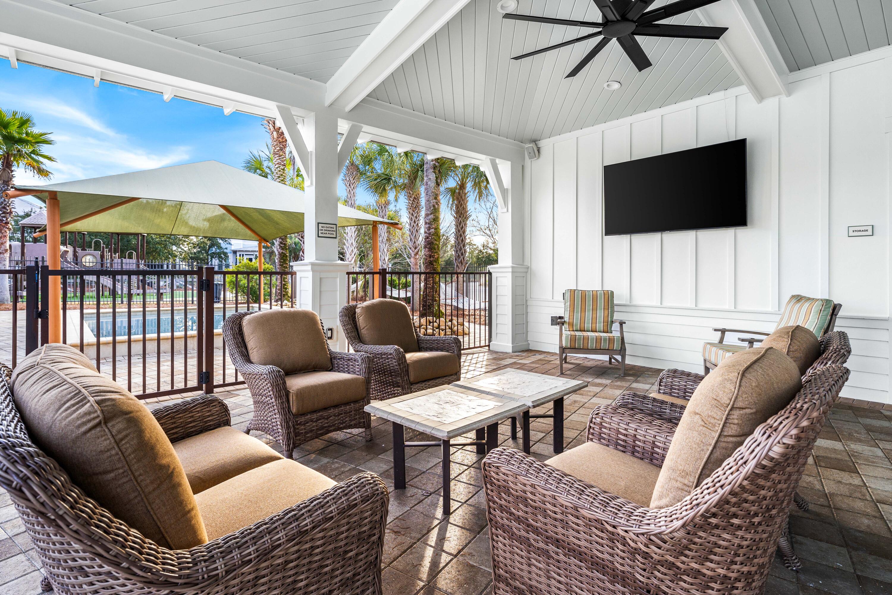 979 Sandgrass Boulevard Santa Rosa Beach, FL 32459 - Photo 64 of 72 a living room with furniture a flat screen tv and a floor to ceiling window