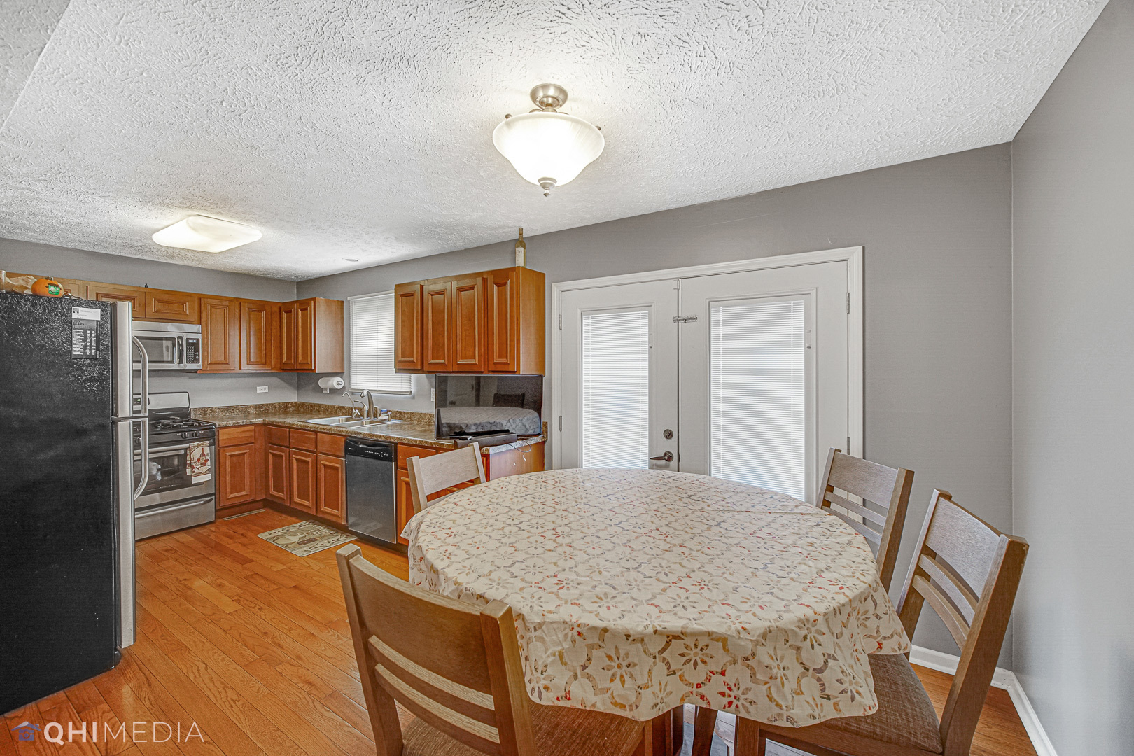 3208 Old Castle Road Joliet, IL 60431 - Photo 4 of 19 a kitchen with stainless steel appliances granite countertop a stove top oven a sink dishwasher a dining table and chairs with wooden floor
