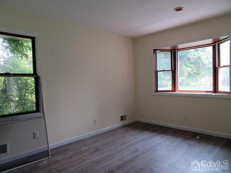 1818 Oak Tree Road Edison, NJ 08820 - Photo 9 of 25 an empty room with wooden floor and windows