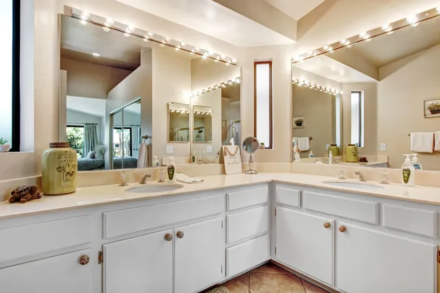 a bathroom with double vanity sinks and a mirror