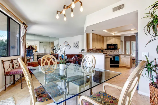 a view of a dining room and livingroom with furniture wooden floor a chandelier
