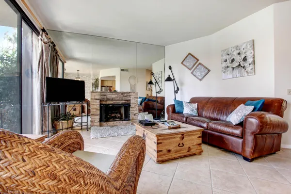 a living room with furniture a flat screen tv and a fireplace