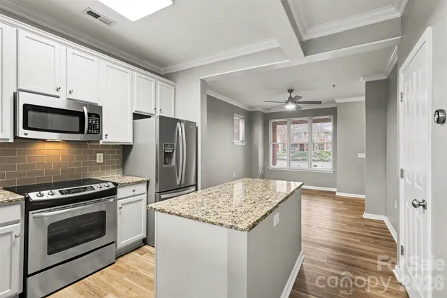 a kitchen with granite countertop a stove and a microwave