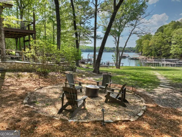 a view of a patio with table and chairs potted plants and large tree
