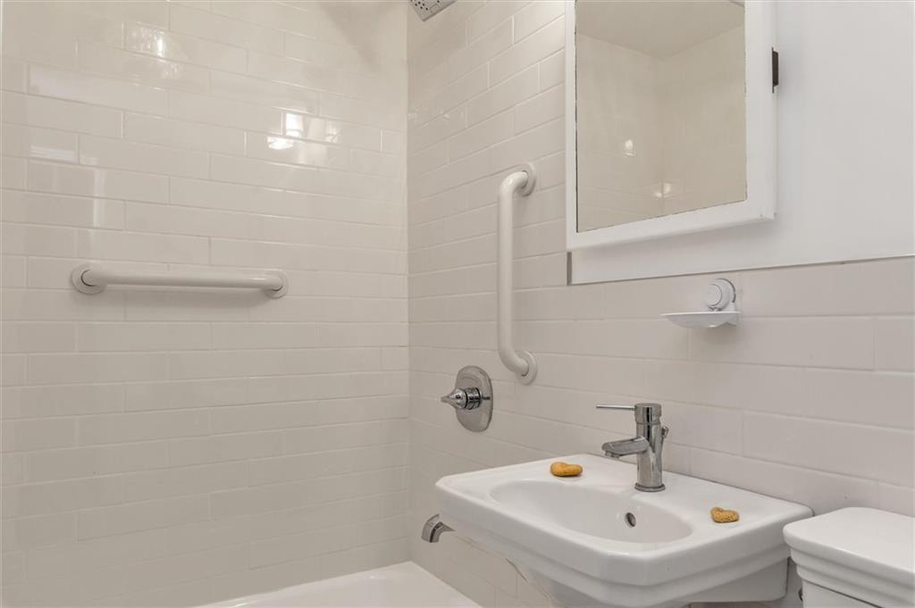 264 Decatur Street Brooklyn, NY 11233 - Photo 11 of 27 a bathroom with a sink a toilet and shower