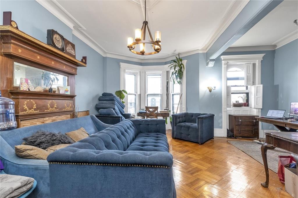 264 Decatur Street Brooklyn, NY 11233 - Photo 20 of 27 a living room with furniture and a chandelier