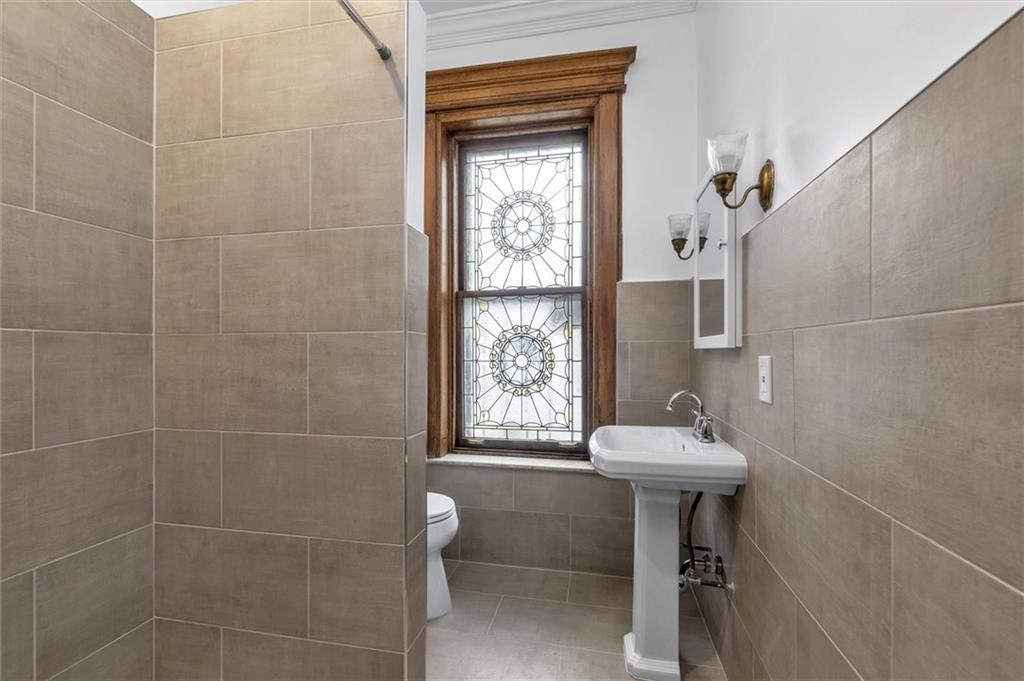 264 Decatur Street Brooklyn, NY 11233 - Photo 22 of 27 a bathroom with a sink toilet and shower