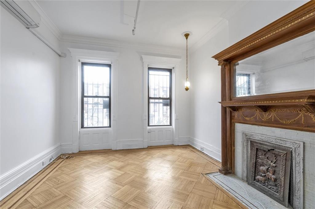 264 Decatur Street Brooklyn, NY 11233 - Photo 23 of 27 an empty room with windows and fireplace