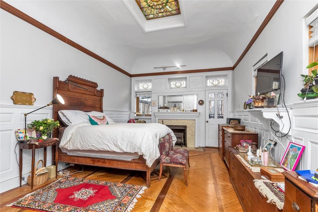 264 Decatur Street Brooklyn, NY 11233 - Photo 9 of 27 a bedroom with a bed and a chandelier