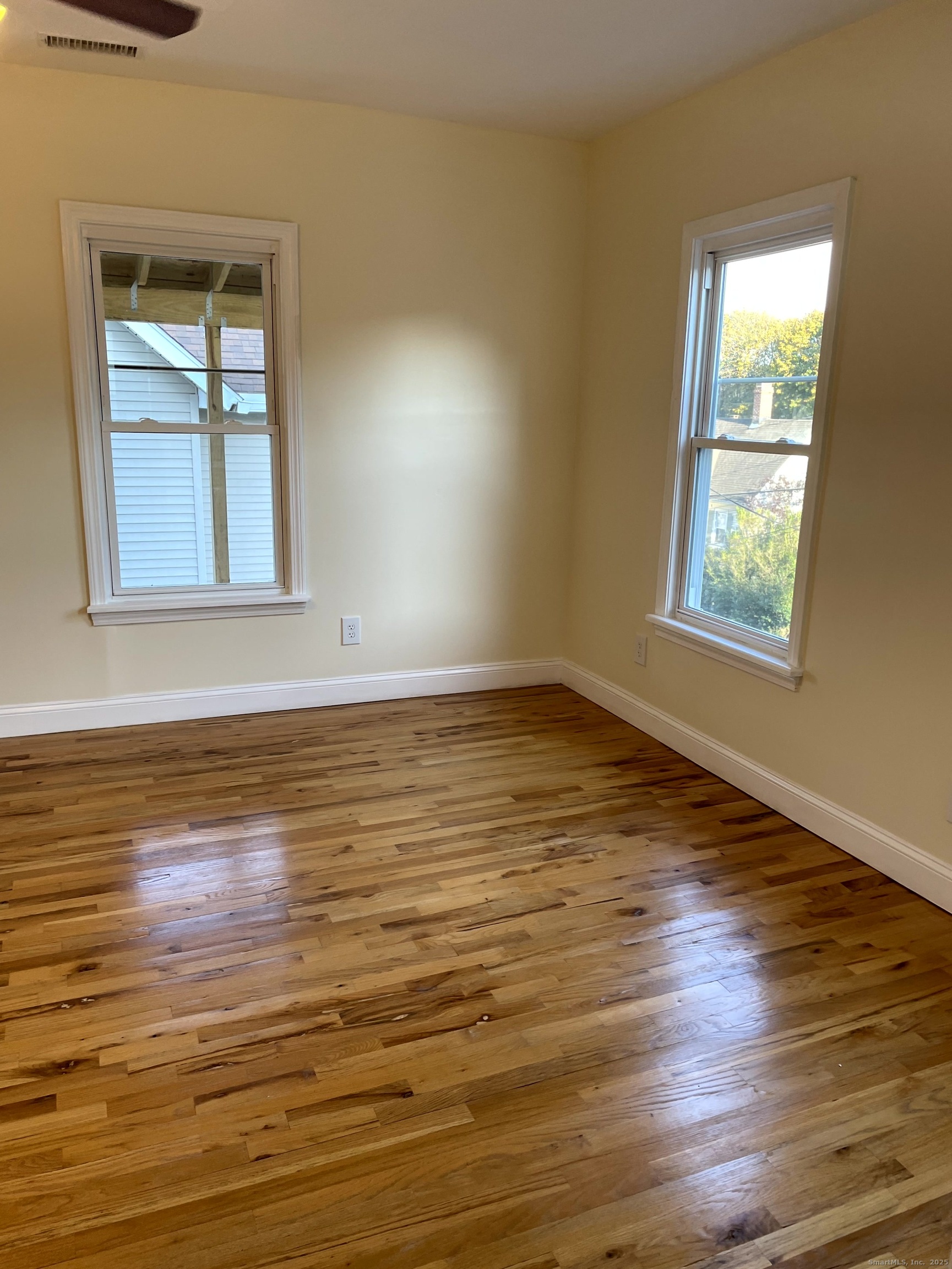 39 Elm Street Shelton, CT 06484 - Photo 4 of 8 a view of an empty room with wooden floor and a window