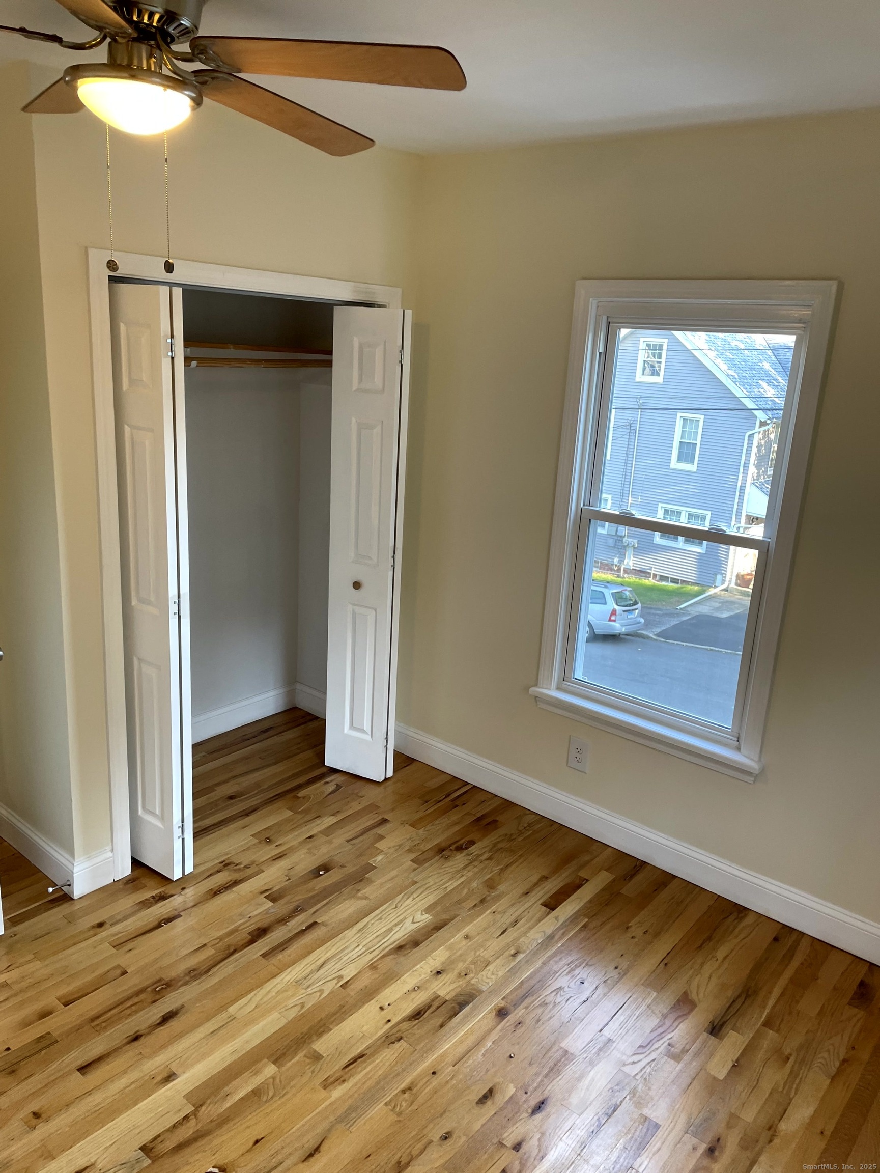39 Elm Street Shelton, CT 06484 - Photo 5 of 8 a view of an empty room with wooden floor and a window