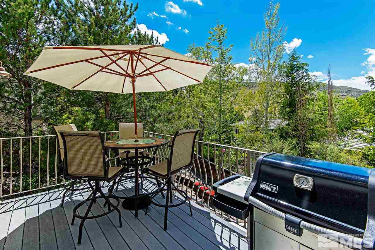 4870 East Creek Ridge Trail Reno, NV 89519 - Photo 15 of 25 a view of a roof deck with table and chairs under an umbrella