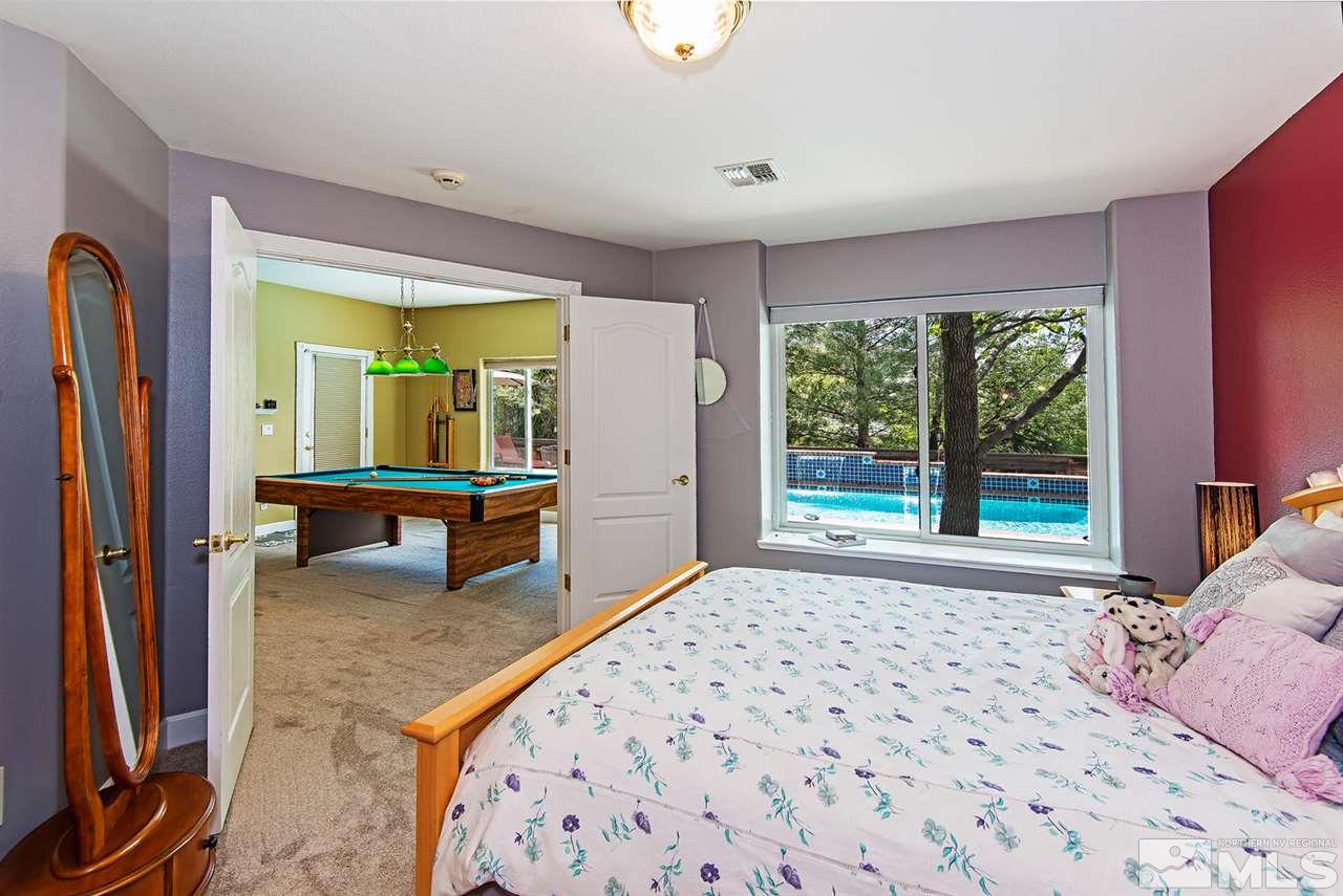 4870 East Creek Ridge Trail Reno, NV 89519 - Photo 19 of 25 a bedroom with a bed and large window with outer view