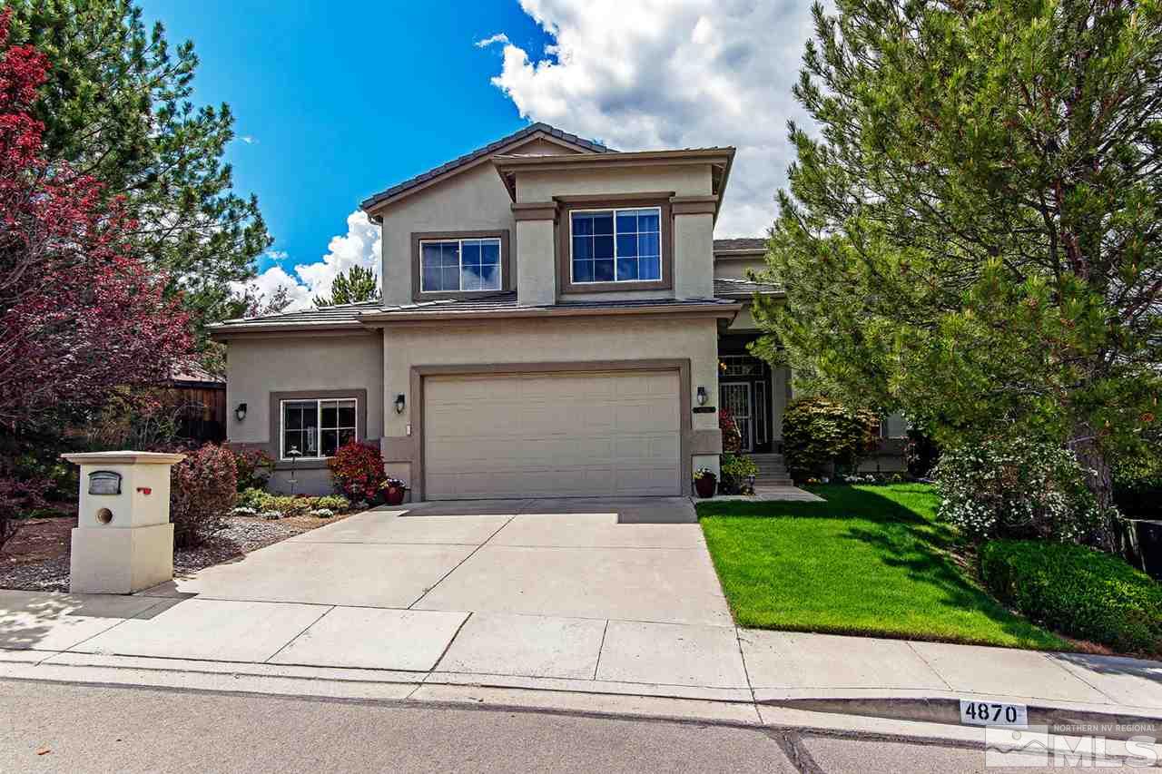 4870 East Creek Ridge Trail Reno, NV 89519 - Photo 4 of 25 a front view of a house with garage and plants
