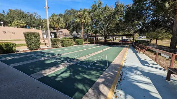 a view of swimming pool with outdoor seating and trees in the background
