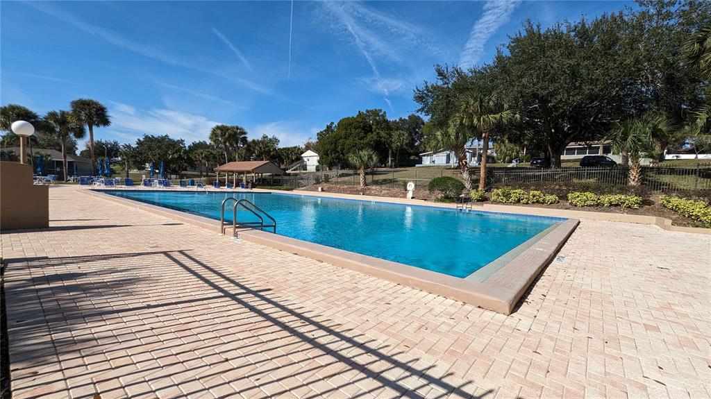 10301 Highway 27, Unit 17 Clermont, FL 34711 - Photo 15 of 19 a view of swimming pool with outdoor seating and trees in the background