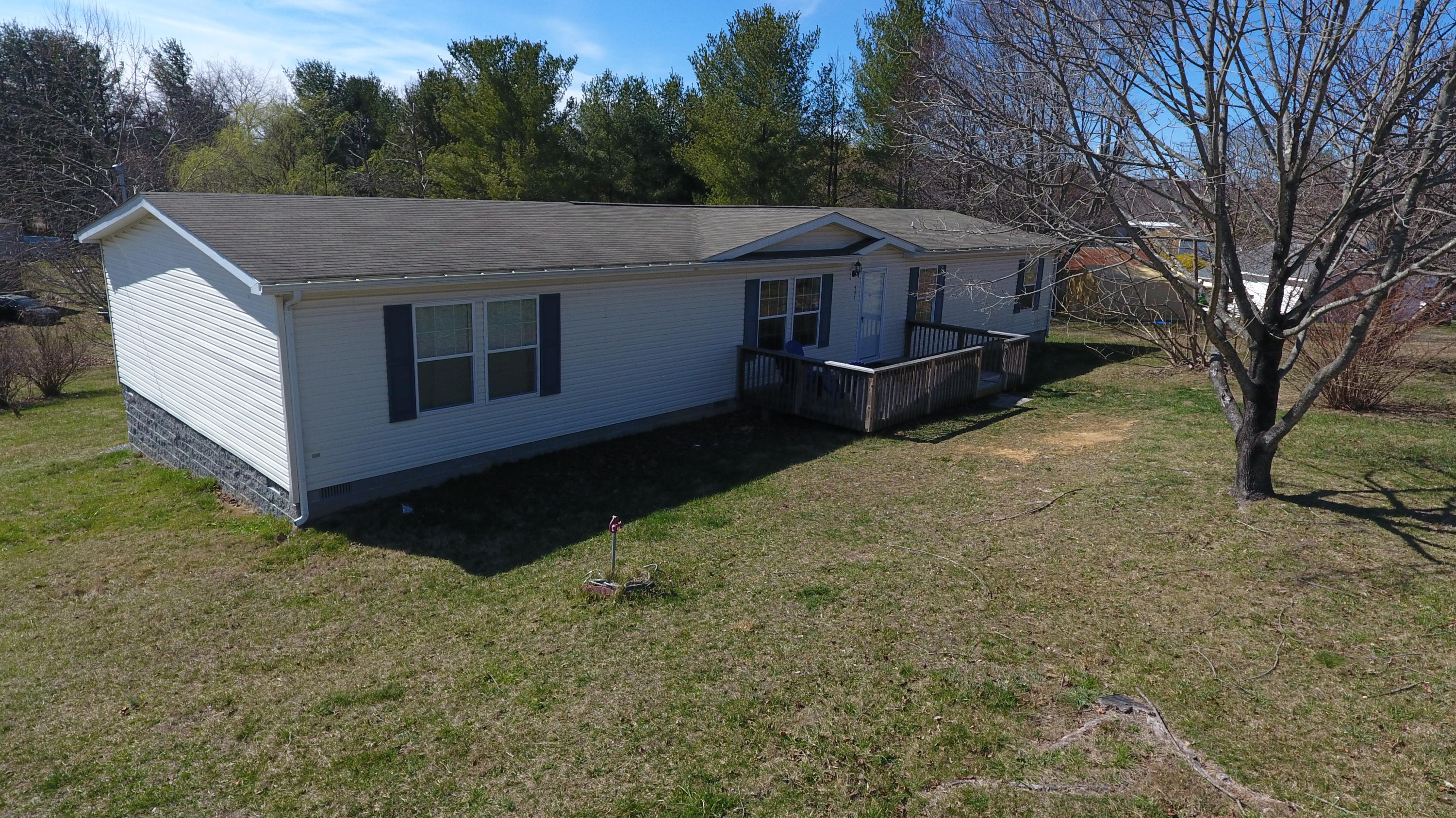 a front view of house with yard and trees in the background
