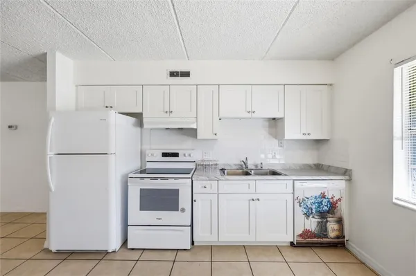 a kitchen with white cabinets and white appliances