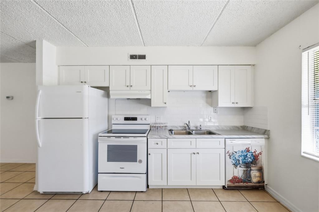 705 Michigan Court, Unit 14 St. Cloud, FL 34769 - Photo 13 of 45 a kitchen with white cabinets and white appliances