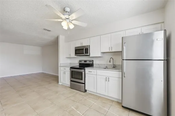 a kitchen with cabinets stainless steel appliances and a refrigerator