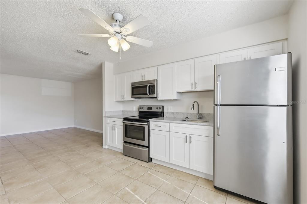 705 Michigan Court, Unit 14 St. Cloud, FL 34769 - Photo 28 of 45 a kitchen with cabinets stainless steel appliances and a refrigerator