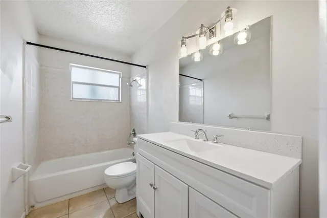 a bathroom with a toilet a sink a mirror and a bathtub