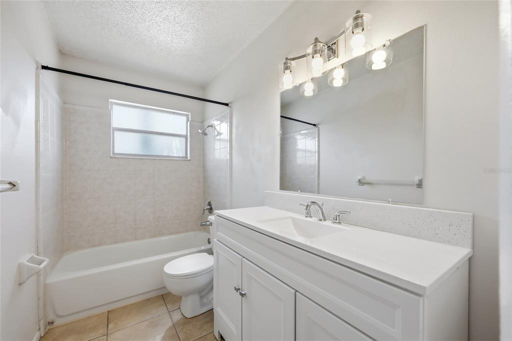 705 Michigan Court, Unit 14 St. Cloud, FL 34769 - Photo 29 of 45 a bathroom with a toilet a sink a mirror and a bathtub