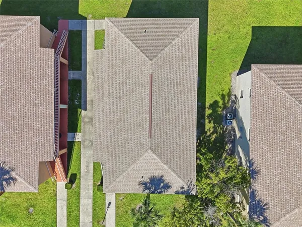 aerial view of a house with a yard and potted plants