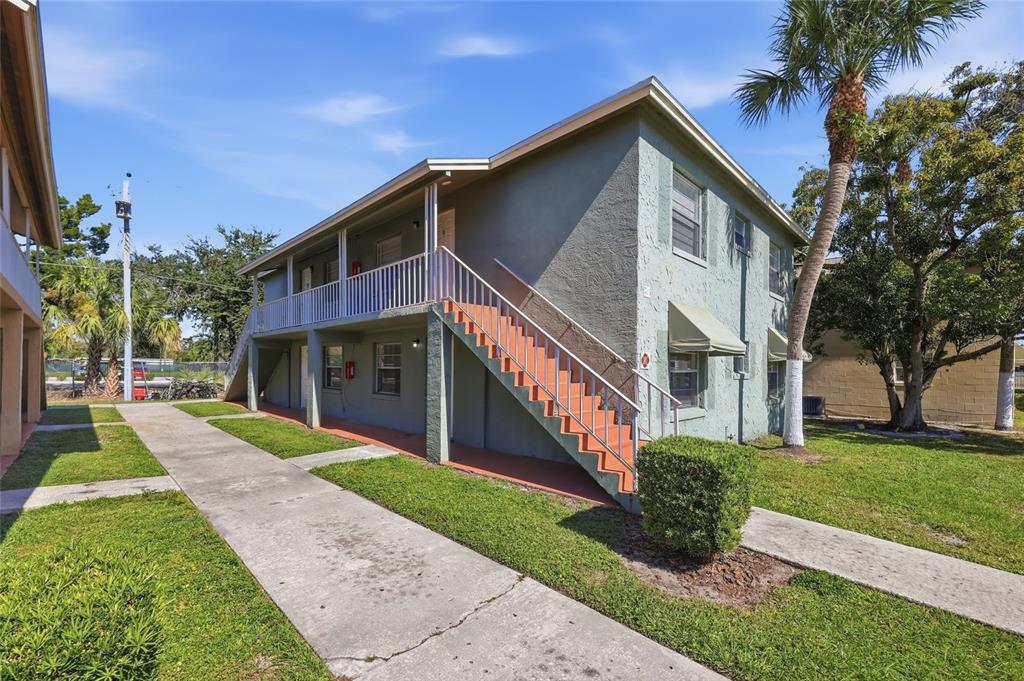 705 Michigan Court, Unit 14 St. Cloud, FL 34769 - Photo 4 of 45 a front view of a house with a yard and potted plants