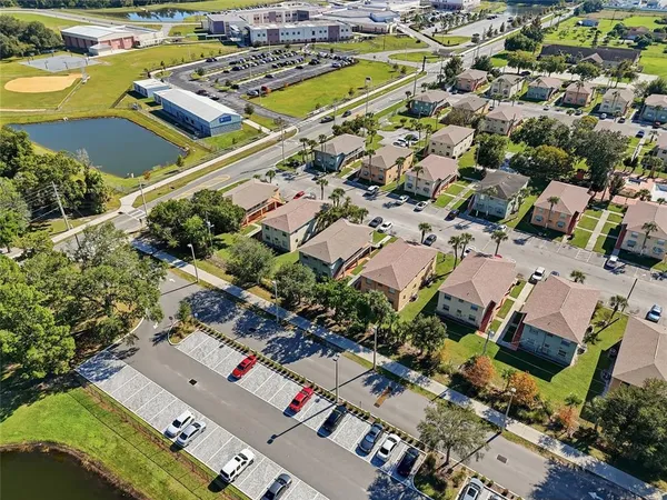 an aerial view of a city with lots of residential buildings and parking space