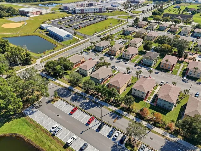 an aerial view of a city with lots of residential buildings and parking space