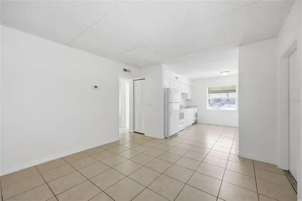 a view of a kitchen with white cabinet and a refrigerator