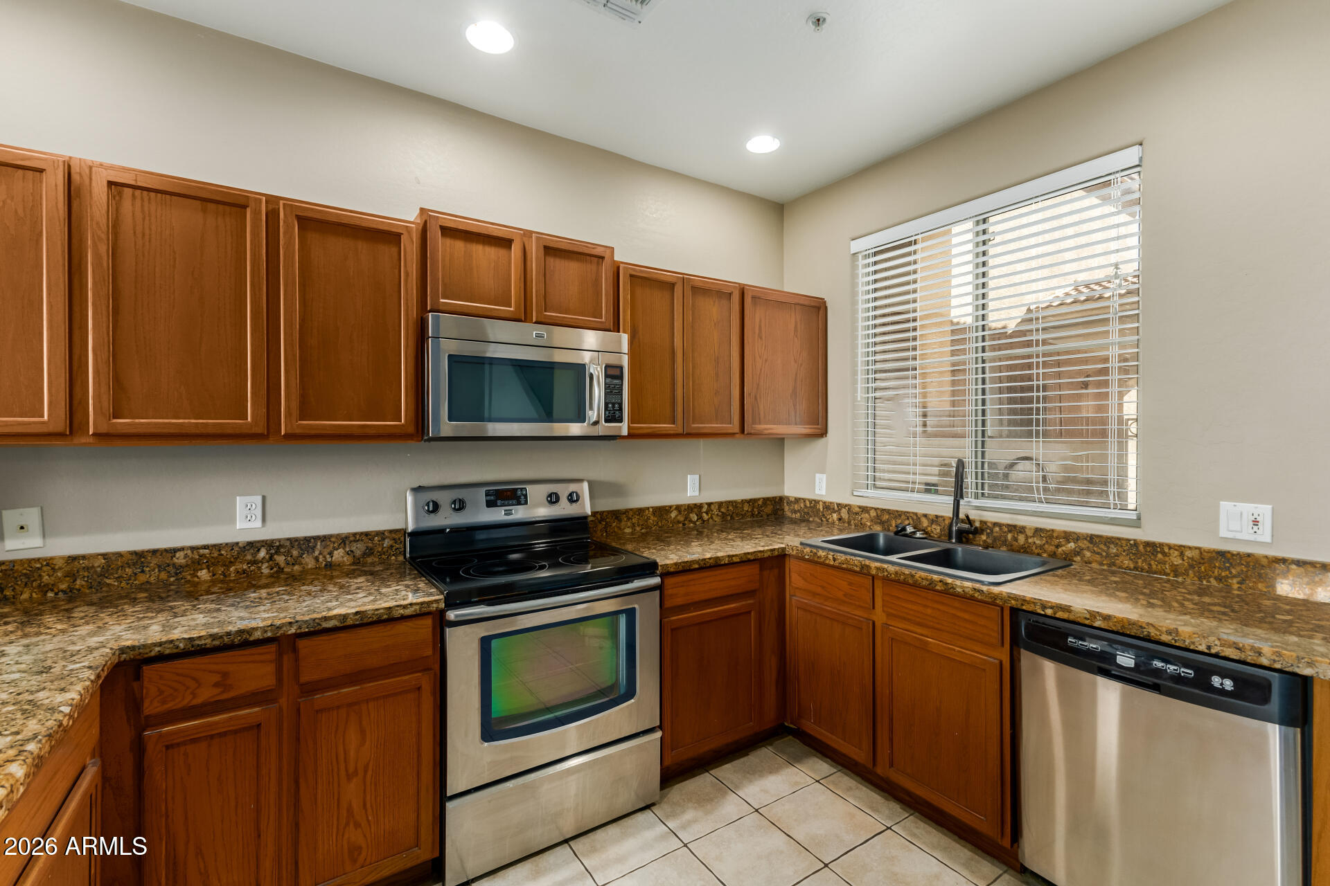 5415 East McKellips Road, Unit 106 Mesa, AZ 85215 - Photo 17 of 45 a kitchen with stainless steel appliances granite countertop wooden cabinets stove a sink and dishwasher
