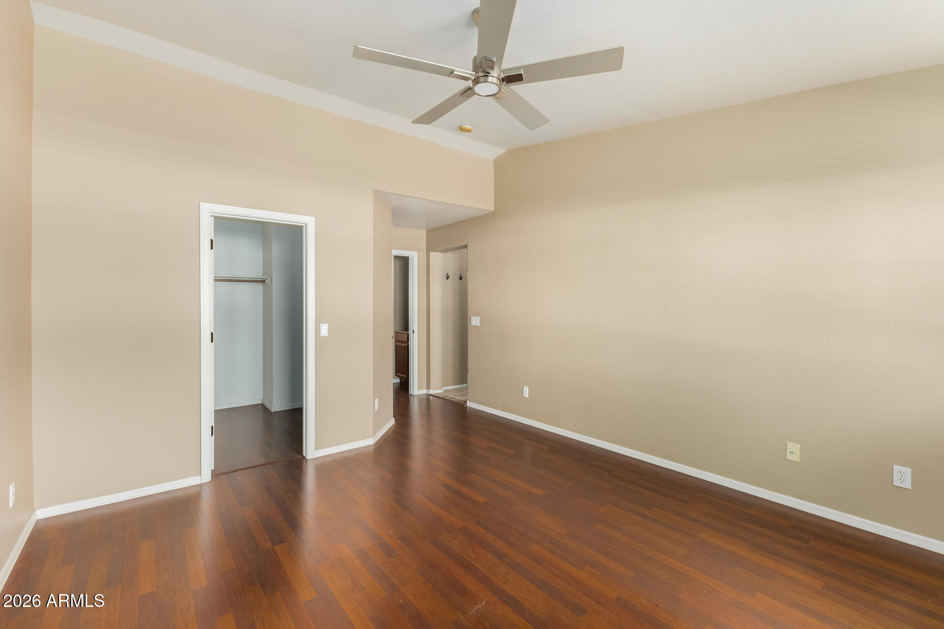 5415 East McKellips Road, Unit 106 Mesa, AZ 85215 - Photo 25 of 45 an empty room with wooden floor and a ceiling fan