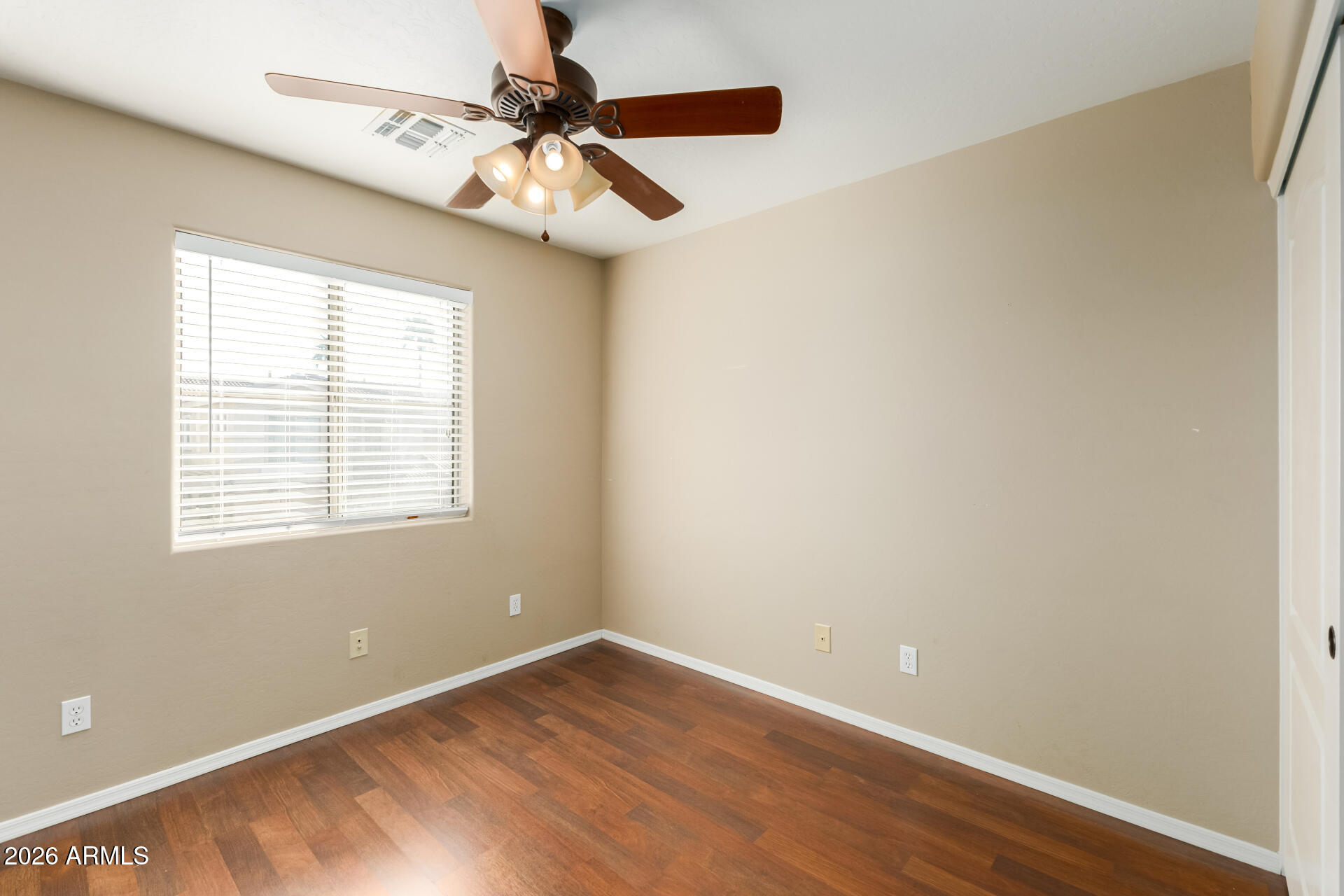 5415 East McKellips Road, Unit 106 Mesa, AZ 85215 - Photo 30 of 45 a view of an empty room with wooden floor and a window
