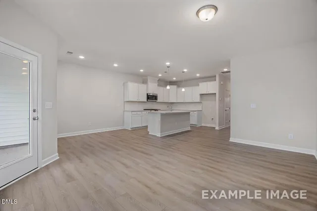 a view of kitchen with kitchen island wooden floor center island and stainless steel appliances