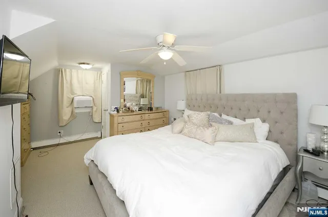 a spacious bedroom with a bed a mirror and a large window