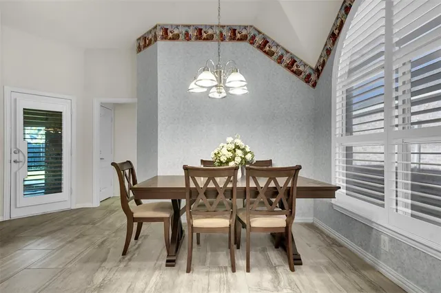 a view of a dining room with furniture a chandelier and wooden floor