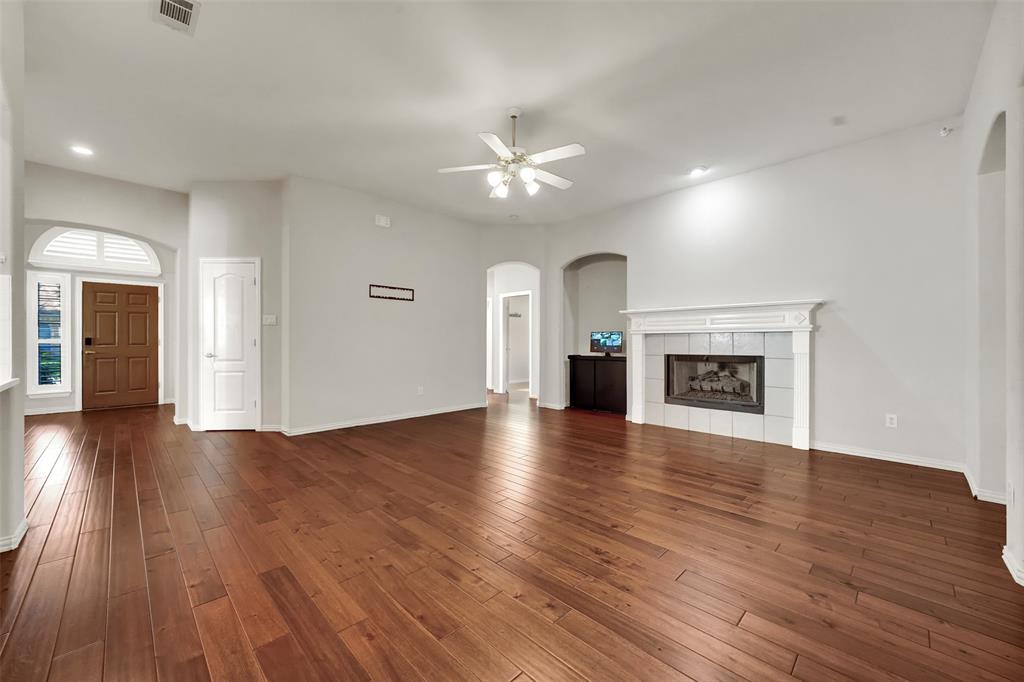 5409 Deer Brook Road Garland, TX 75044 - Photo 13 of 31 an empty room with wooden floor fireplace and windows